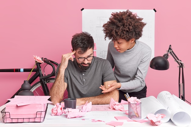 Team von Studentinnen und Studenten arbeiten zusammen an der Skizze der Gebäudeplanung, arbeiten an der Lösung von Problemen auf dem Desktop zusammen