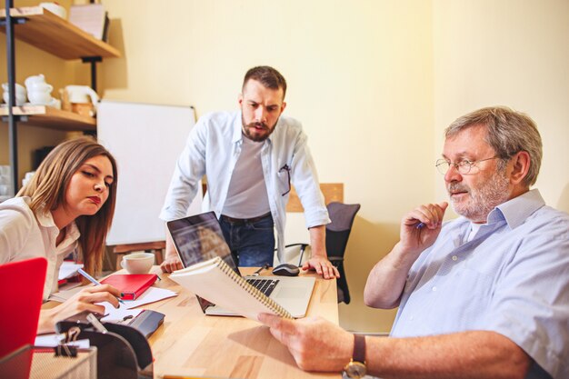 Teamjob. Foto junge Geschäftsleute, die mit neuem Projekt im Büro arbeiten