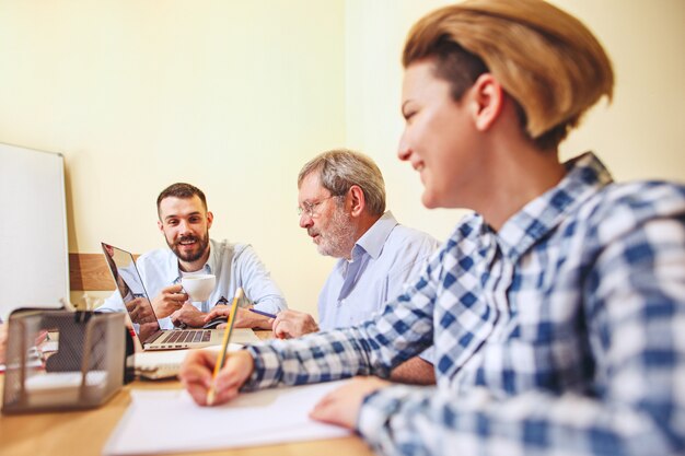 Teamjob. Foto junge Geschäftsleute, die mit neuem Projekt im Büro arbeiten