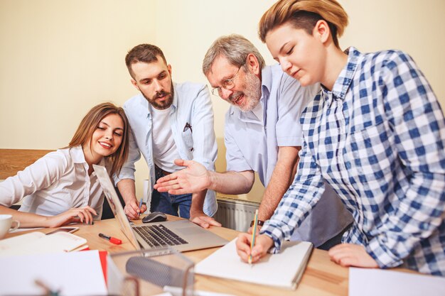 Teamjob. Foto junge Geschäftsleute, die mit neuem Projekt im Büro arbeiten