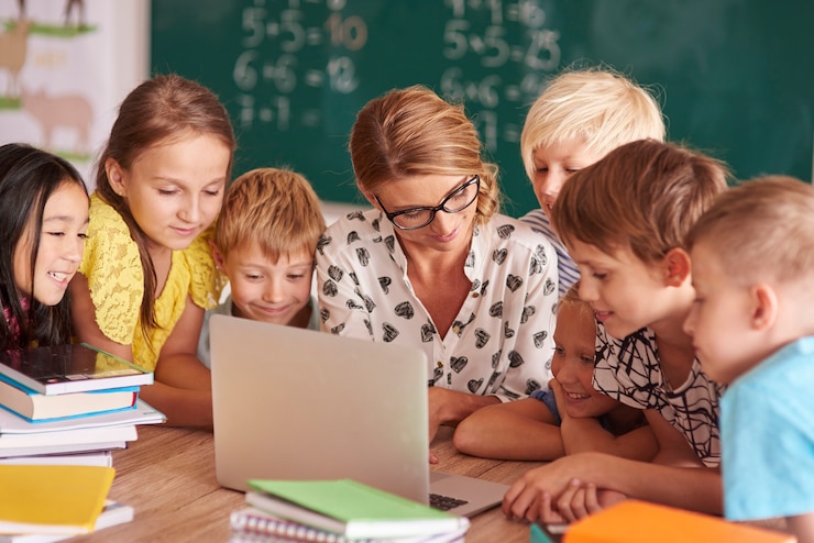 Kostenlose Foto teamwork über den laptop des lehrers