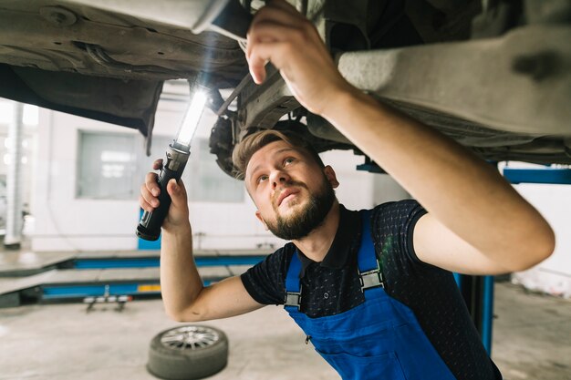 Techniker, der Fahrzeugboden überprüft