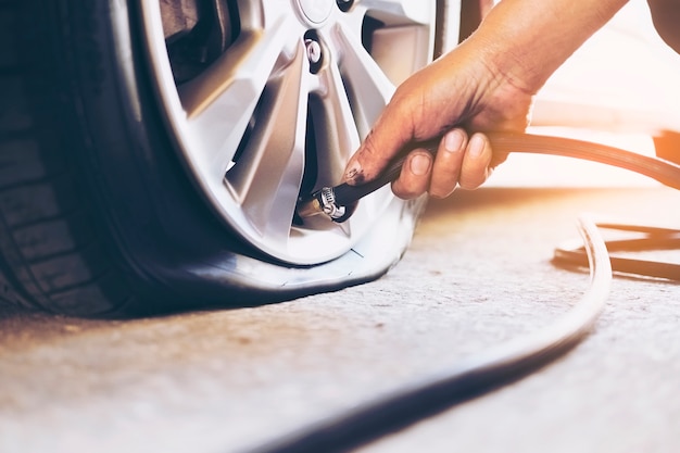 Techniker repariert flachen Reifen des Autos