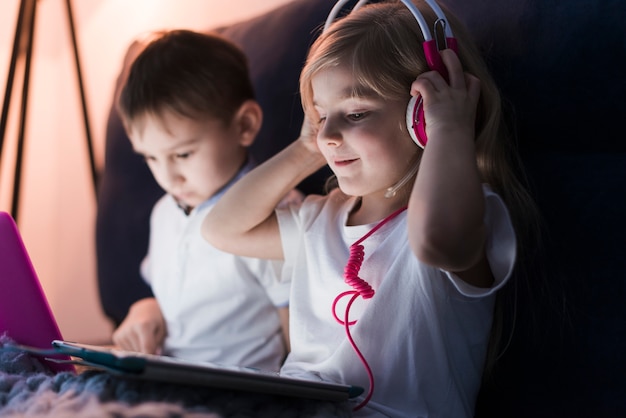 Technologiekonzept mit den Kindern, die Kopfhörer tragen