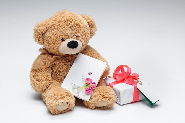 Teddybärenpaar mit rotem Herzen und Geschenk auf Weiß.