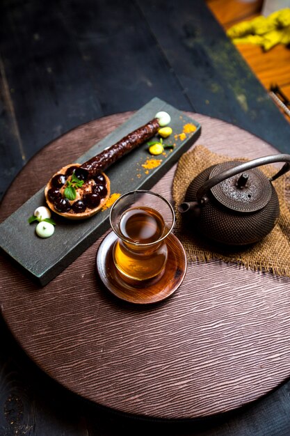 Tee im Armudu-Glas, chinesische Teekanne und Schokoladentartaleta