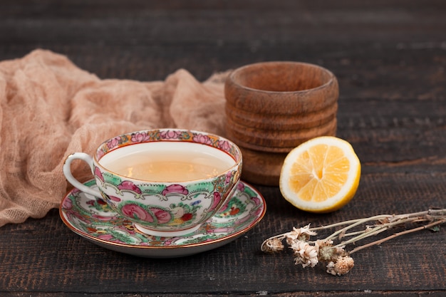 Tee mit Zitrone und Primeln auf dem Tisch