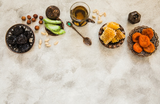 Kostenloses Foto teeglas mit trockenfrüchten und bienenwabe