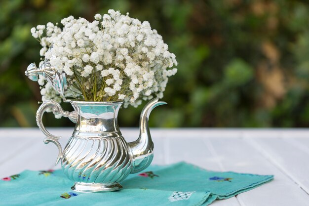 Teekanne mit weißen Blüten
