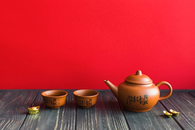 Teekanne und Tassen auf Holztisch