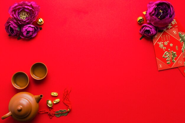 Teekanne und Tassen in der Nähe von Blumen