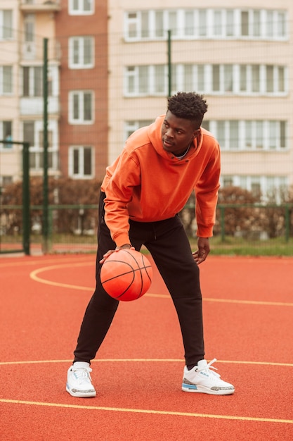 Teenager, der draußen Basketball spielt
