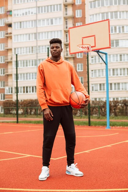 Teenager, der draußen Basketball spielt