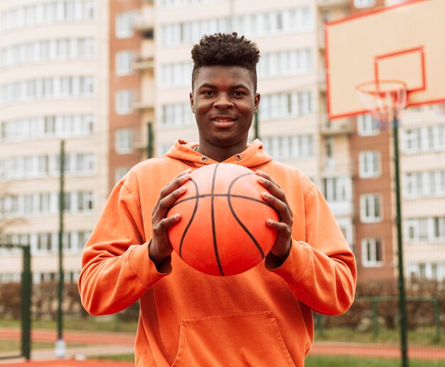 Teenager, der draußen Basketball spielt