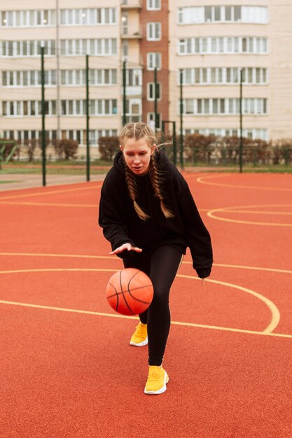 Teenager, der draußen Basketball spielt