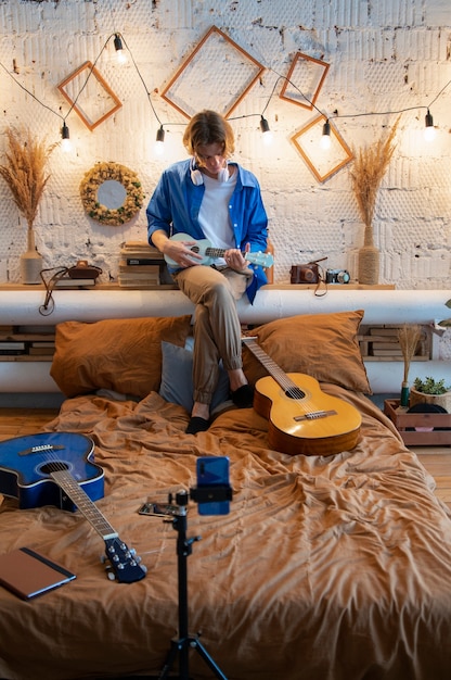 Teenager, der Musik mit seiner Gitarre in seinem Heimstudio aufnimmt