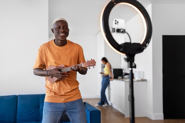 Teenager der Vorderansicht, der die Ukulele spielt