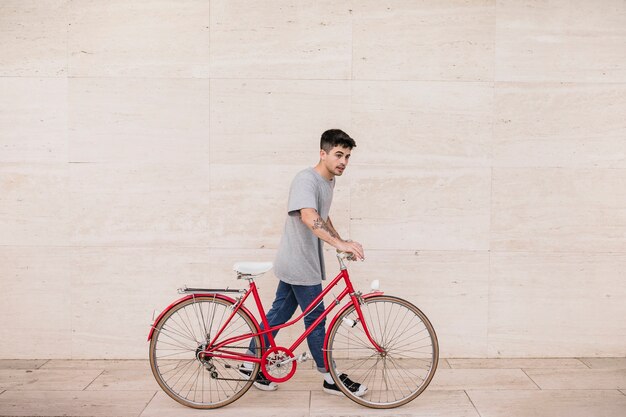 Teenager, der zusammen mit seinem Fahrrad geht