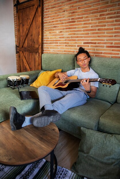 Kostenloses Foto teenager in vollaufnahme, der zu hause musik macht