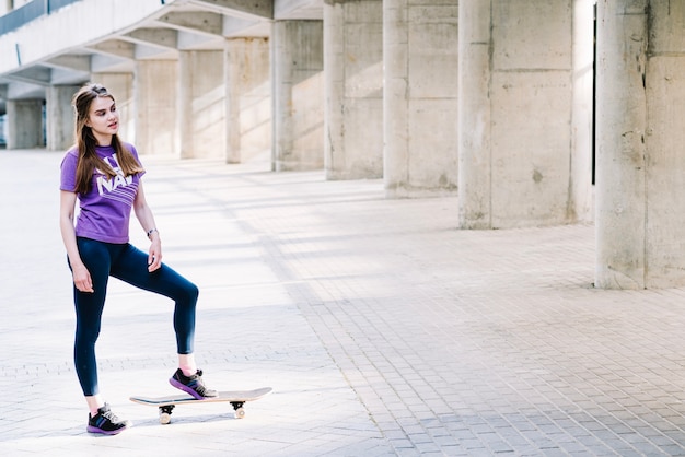 Teenager landet ihren Fuß auf ihrem Skateboard