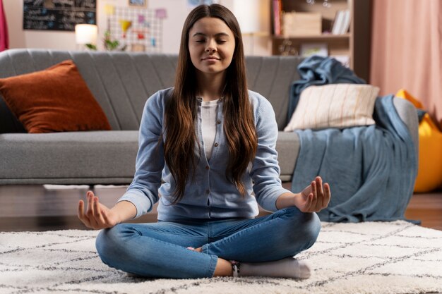 Teenager-Mädchen beim Yoga zu Hause