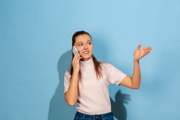 Teenager-Mädchen, das auf Smartphone spricht und lächelt