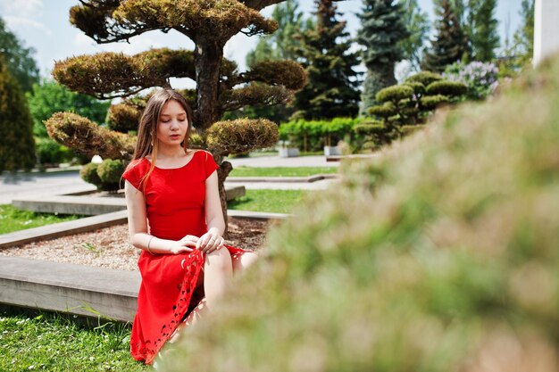 Teenager-Mädchen im roten Kleid posierte im Freien an einem sonnigen Tag