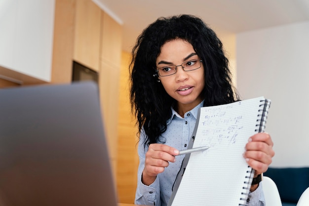 Kostenloses Foto teenager-mädchen zu hause während der online-schule mit laptop und notizbuch