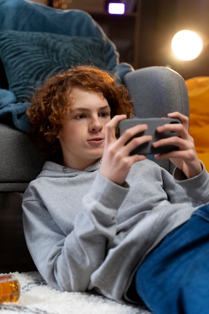 Kostenloses Foto teenager mit smartphone zu hause