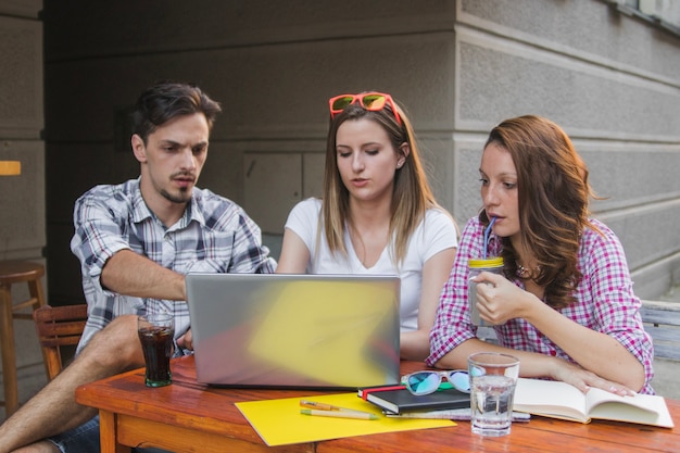 Teens mit Getränken und Laptop