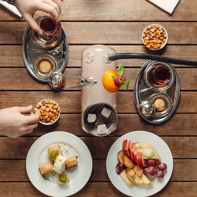 Kostenloses Foto teeservice mit draufsicht der imbissbonbons und -früchte