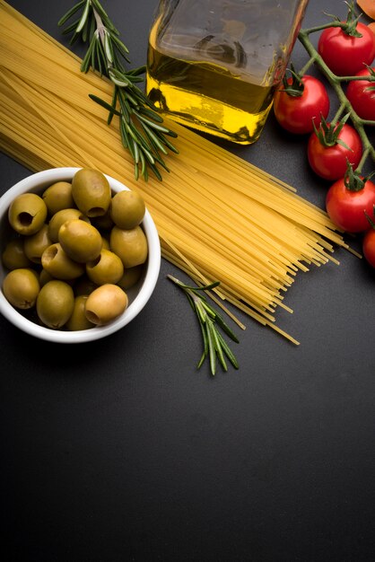 Teigwaren und Zutaten zum Kochen auf dunklem Hintergrund