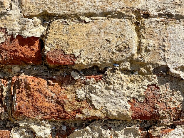 Teil einer alten Backsteinmauer mit Ziegeln schließen oben.