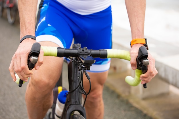 Teilansicht des Mannes, der Fahrrad nahe Meer reitet