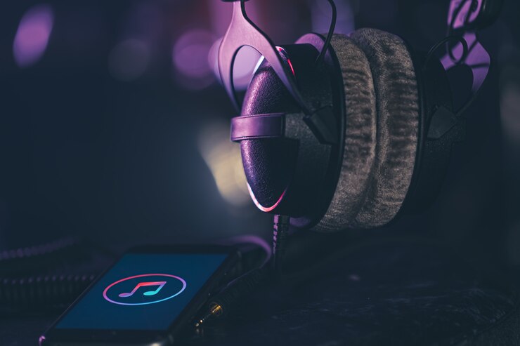 Kostenlose Foto telefon mit musikikone und kopfhörern auf unscharfem hintergrund, musikhörenkonzept, kopienraum.