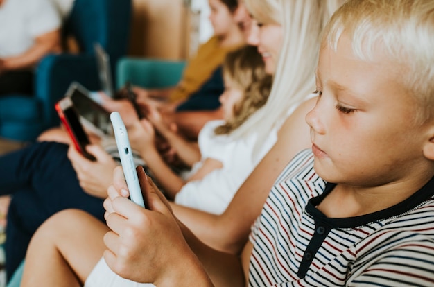 Telefonsüchtige Familie, die ihre Telefone auf der Couch benutzt