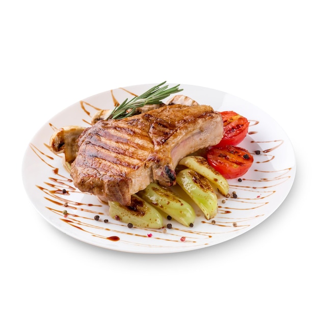 Teller mit gegrilltem Steakfleisch mit Gemüse auf weißem Hintergrund. Foto für die Speisekarte