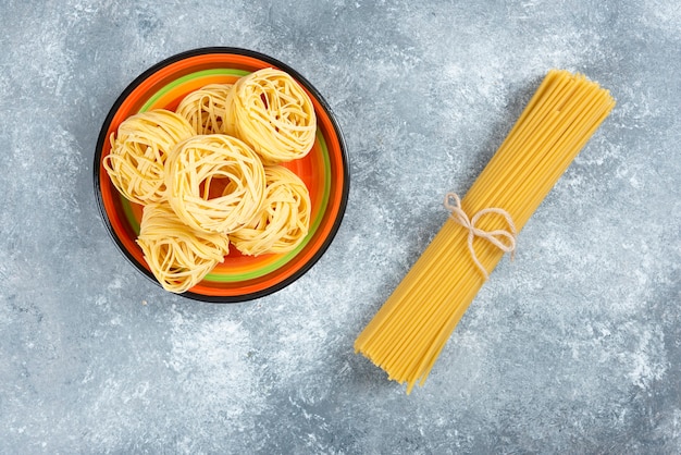 Kostenloses Foto teller mit nudeln und spaghetti auf marmorhintergrund.