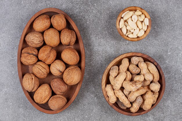 Teller mit Walnüssen, Erdnüssen und Cashewnüssen auf Marmoroberfläche