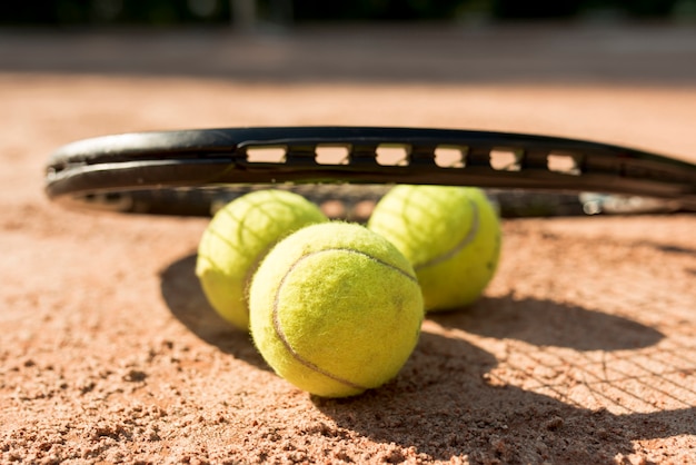 Tennisbälle und schwarzer Schläger