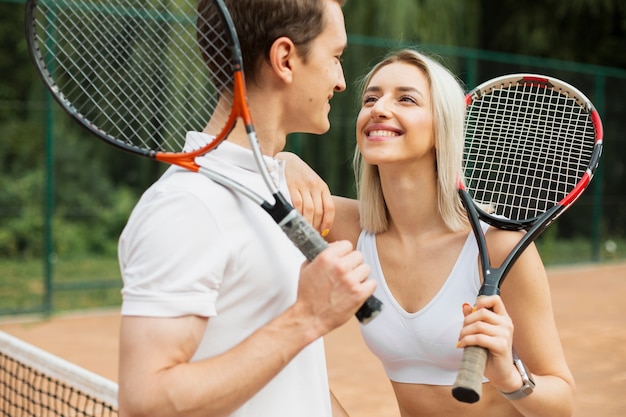 Tennispaare, die an einander lächeln