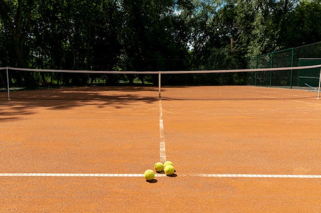 Tennisplatz mit tennisbällen auf dem boden