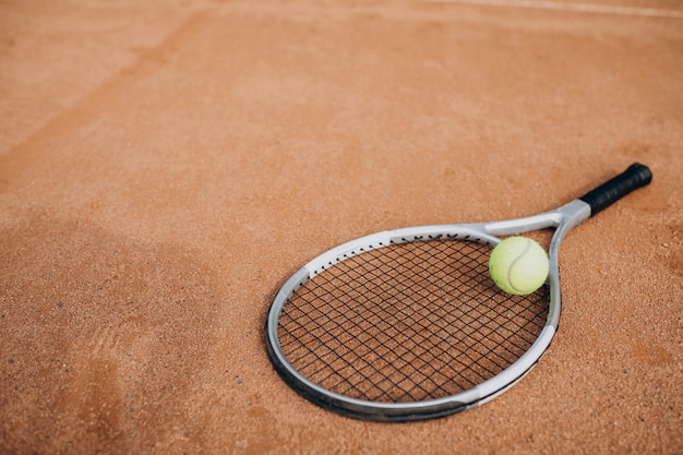 Tennisschläger mit Tennisball am Platz liegend