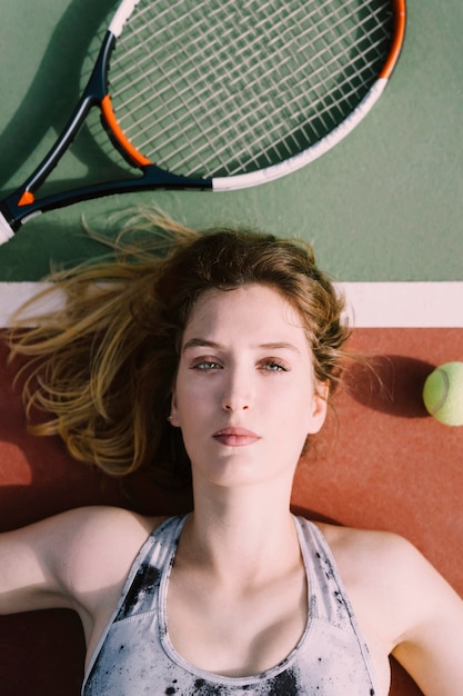 Kostenloses Foto tennisspieler auf dem boden liegend