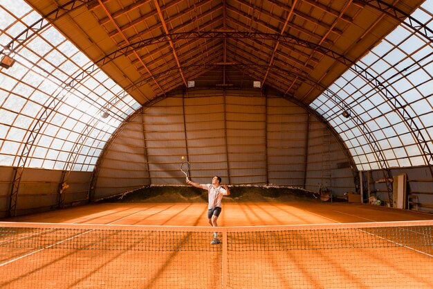 Tennisspieler, der in der Halle dient