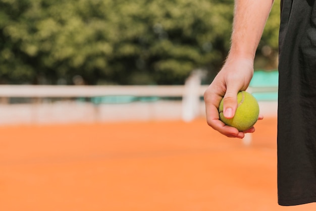 Tennisspieler, der Tenniskugel anhält