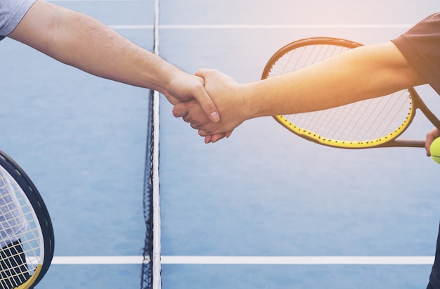 Kostenloses Foto tennisspieler, die hand vor match im tennisgericht rütteln