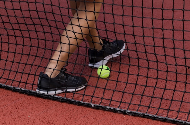 Tennisspielerfüße nahe bei Netz