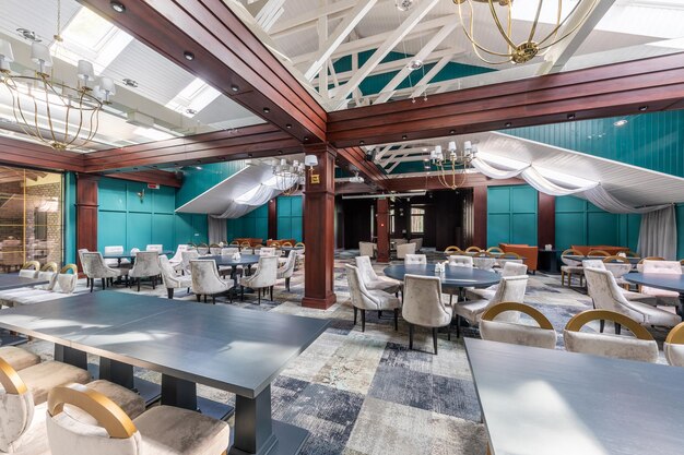 Teure moderne restauranteinrichtung mit designermöbeln und smaragdgrünen wänden, großen mahagonibalken
