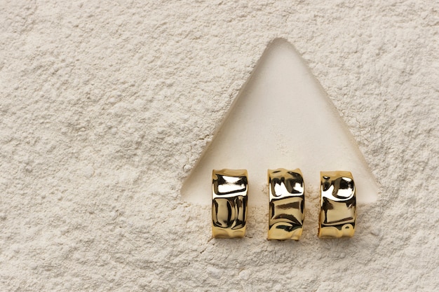 Kostenloses Foto teurer goldener ring mit weißem pulverhintergrund